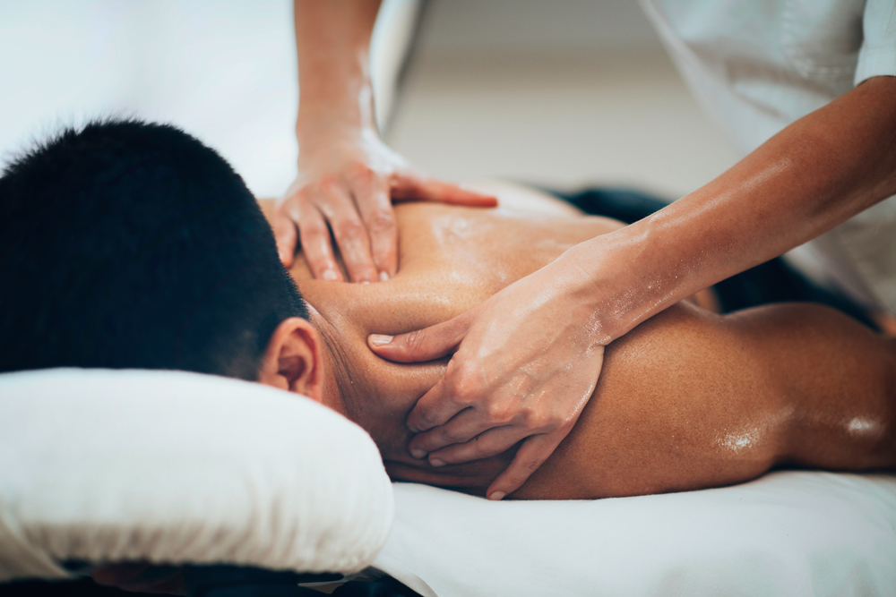 asian-massage-blue-sky-health-center-los-angeles Male client receiving oil-based Asian massage on upper back