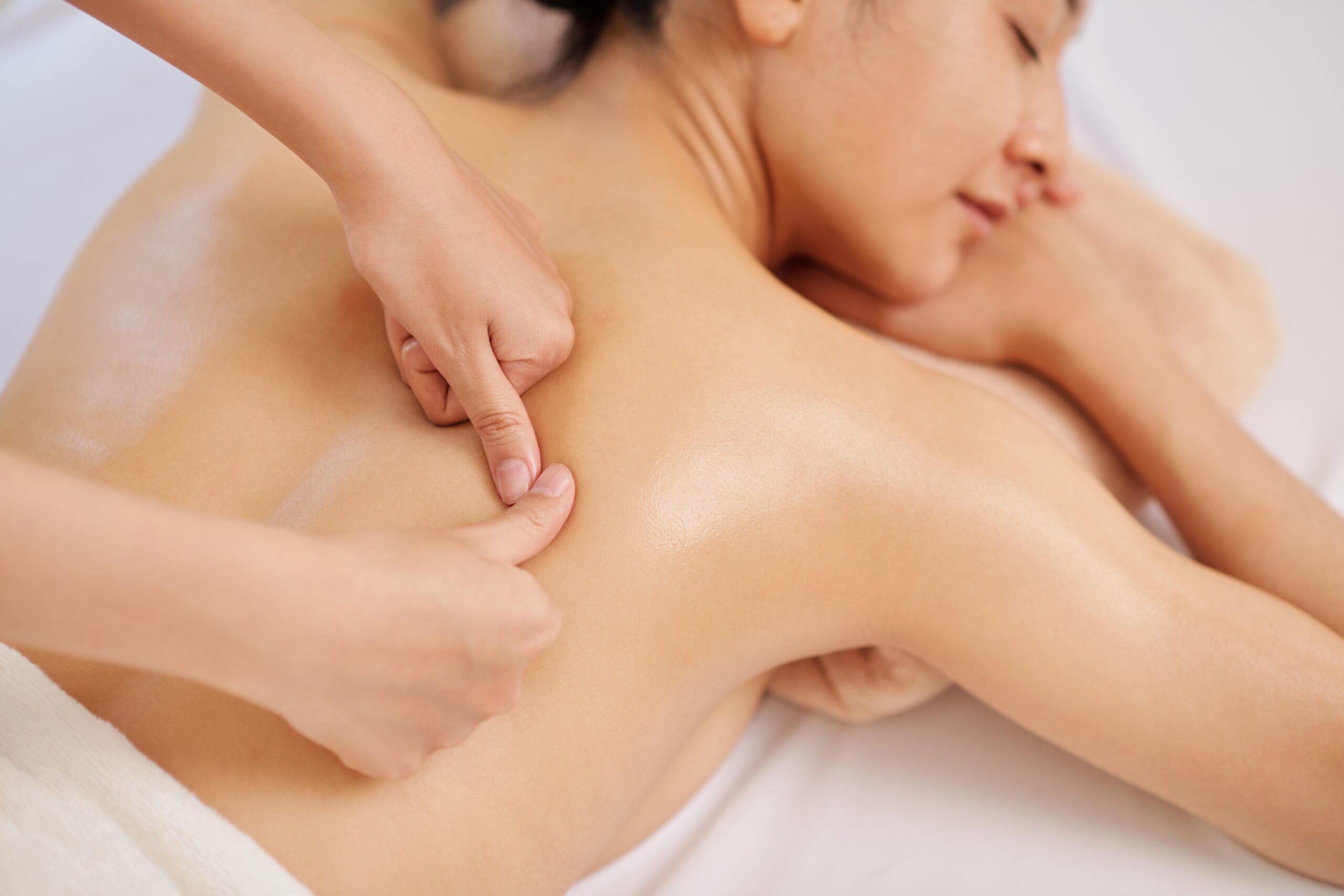 Masseur,Giving,Deep,Tissue,Back,Massage,To,Young,Female,Client Therapist performing detailed back massage on relaxed client